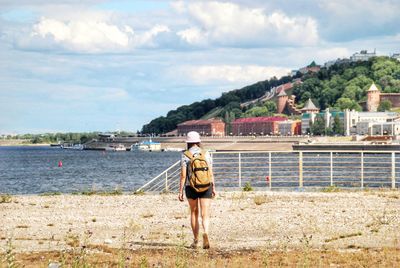 Rear view of man looking at sea against sky