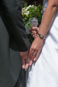 Midsection of couple holding hands