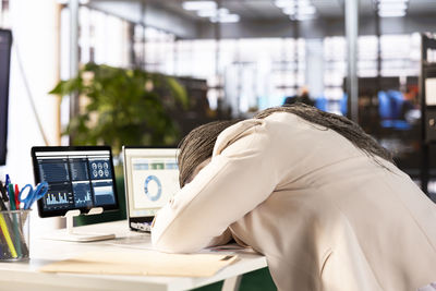 Side view of woman using laptop at office