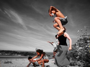 Side view of mother holding daughter on beach