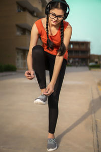 Portrait of young woman exercising on road