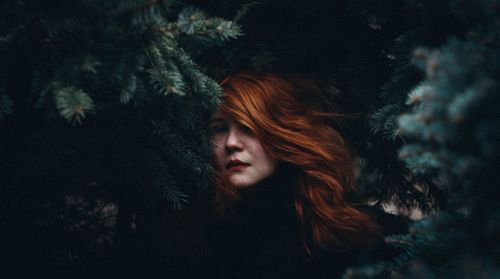 Young woman with christmas tree at night