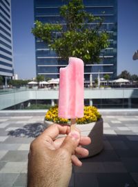 Close-up of hand holding ice cream cone in city