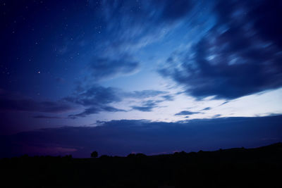 Low angle view of silhouette landscape against sky at night