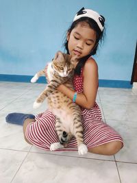 Full length of girl with arms raised on floor