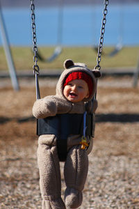 Cute toddler on swing at playground