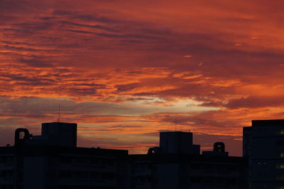 Silhouette city against orange sky