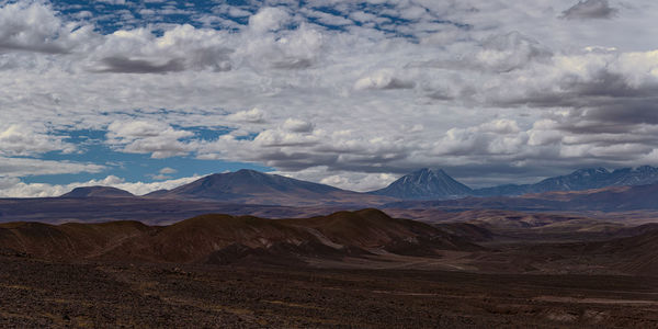 Scenic view of mountains against cloudy sky