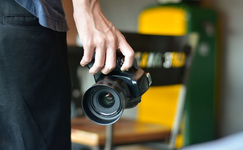 Midsection of man holding camera