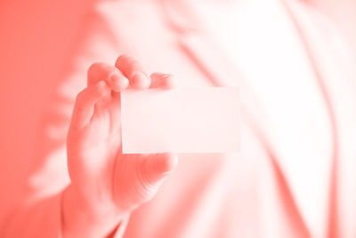 Close-up of person holding hand over white background