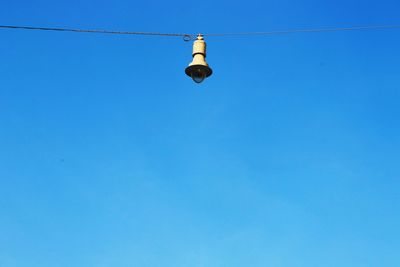 Low angle view of light bulbs against blue sky