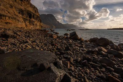 Rocks on beach against sky