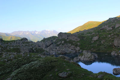 Scenic view of river and mountains against clear sky