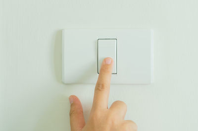 Midsection of person holding camera against wall