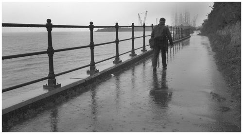 People standing on pier over sea against sky