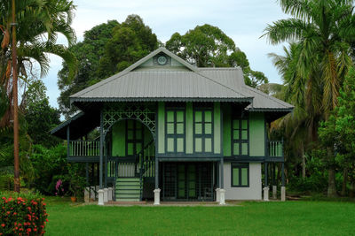 Built structure in lawn by house against sky