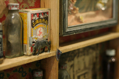 Close-up of animal toy by bottle and box on shelf