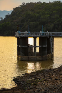 Built structure by lake against sky