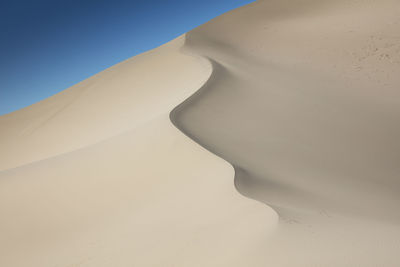 Close-up of sand dunes against clear sky