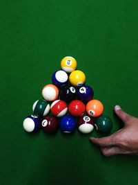 Cropped image of person by balls on pool table