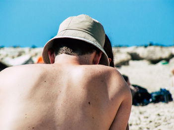 Midsection of shirtless man on beach