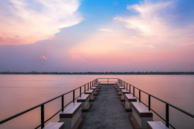 Pier over sea against sky during sunset