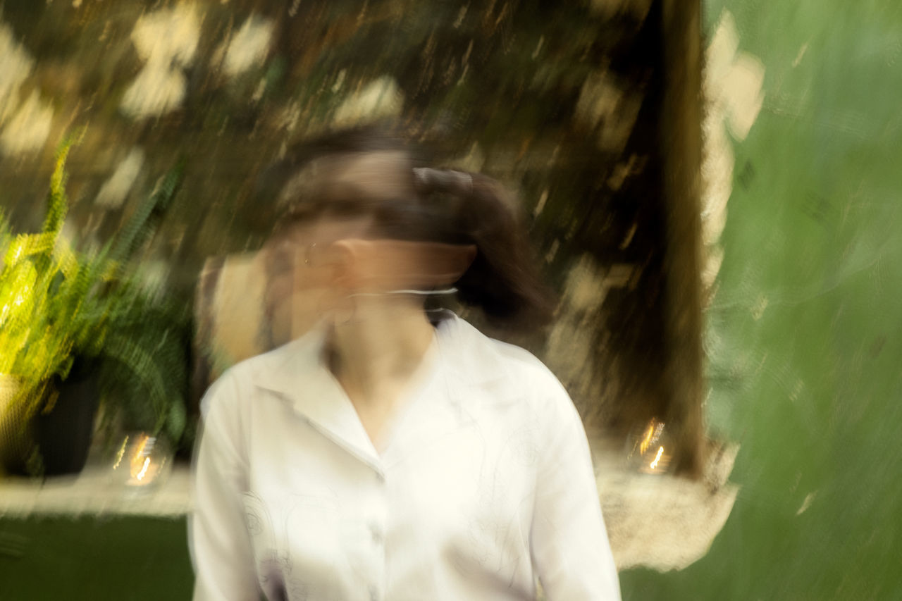 PORTRAIT OF PERSON STANDING BY TREE TRUNK