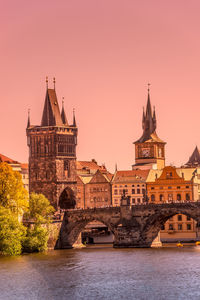 Arch bridge over river against buildings in city