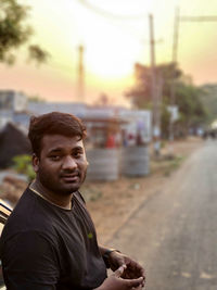 Portrait of young man standing on street in city