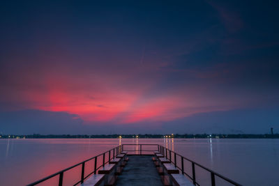 Pier over sea against sky during sunset