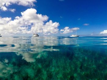 Boats sailing in sea against sky