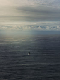 Sailboat sailing in sea against sky during sunset