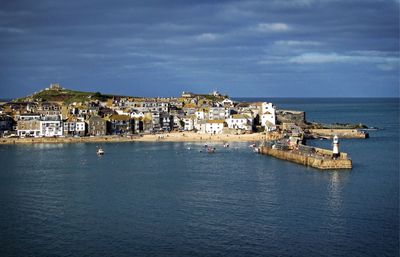 View of town in sea against cloudy sky