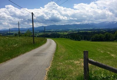 Country road passing through grassy field