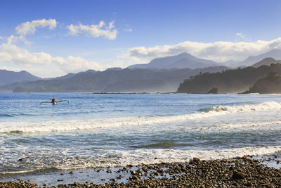 Scenic view of sea and mountains against sky