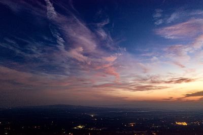 Scenic view of illuminated city against sky during sunset