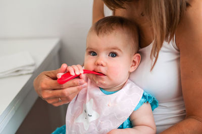 Mother feeding cute baby girl vegetable puree from a spoon. healthy eating nutrition for little kids