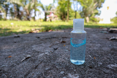Close-up of water bottle on empty road