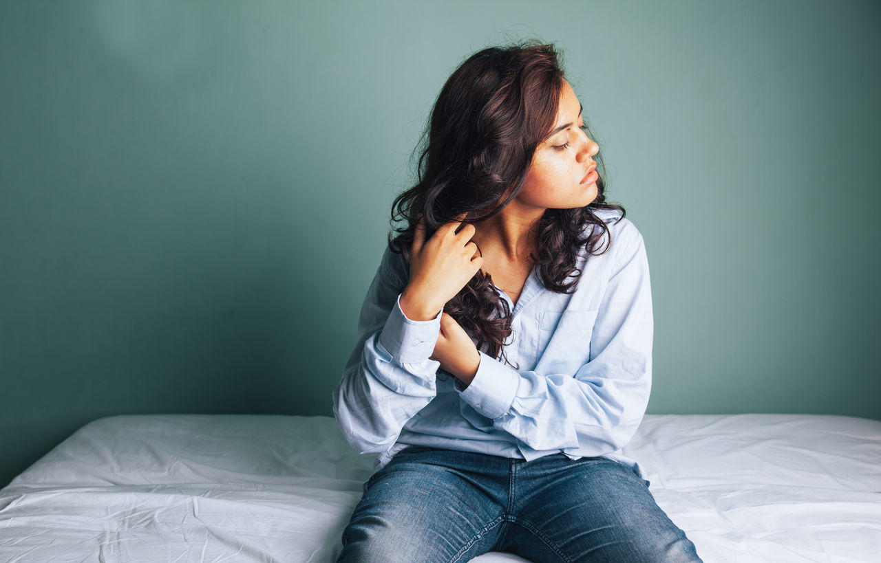 BEAUTIFUL WOMAN SITTING ON BED