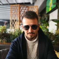 Portrait of smiling young man wearing sunglasses at restaurant