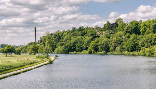 Scenic view of river amidst trees against sky