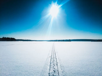 Scenic view of frozen lake against clear blue sky