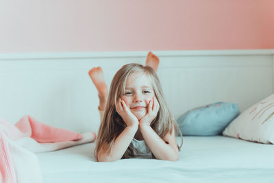 Portrait of cute girl lying on bed at home