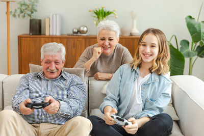 Portrait of smiling family sitting on sofa at home