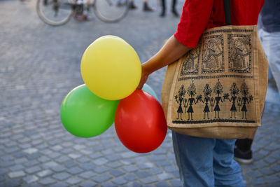 Low section of person holding balloons