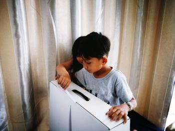 Siblings opening box at home