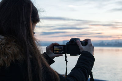 Rear view of woman photographing camera