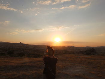 Woman photographing at sunset