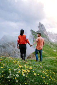 Rear view of women on mountain against sky