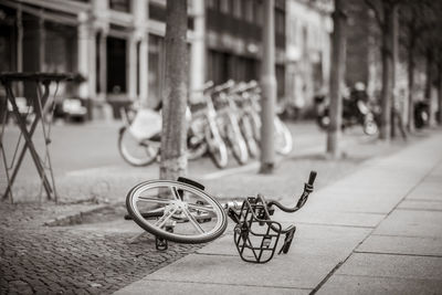 Bicycle on footpath by street against buildings in city